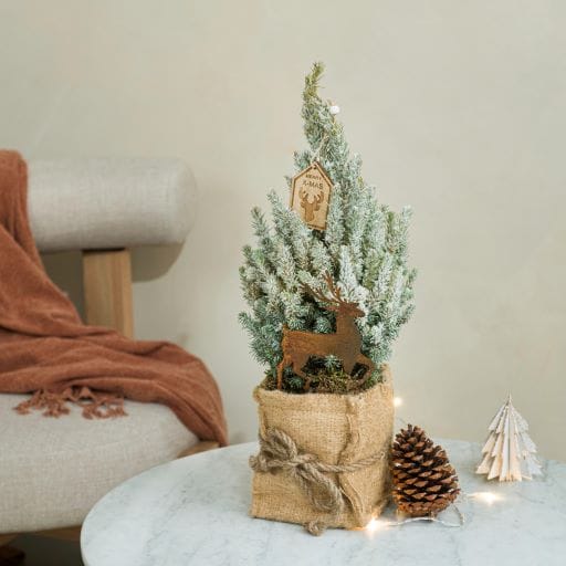 mini abete innevato e decorato con pigne ed elementi in legno