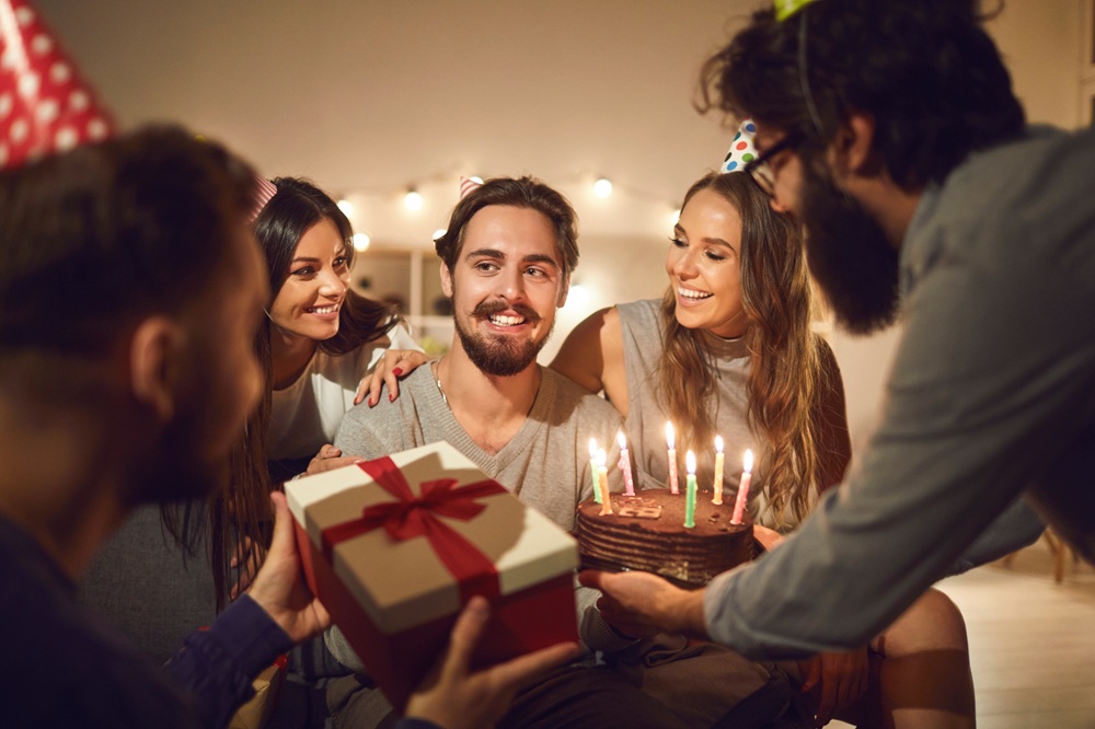 Festa di compleanno per un uomo con gli amici, regali e torta