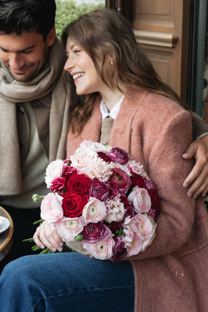 coppia con un bouquet di fiori allegri seduta in un ristorante