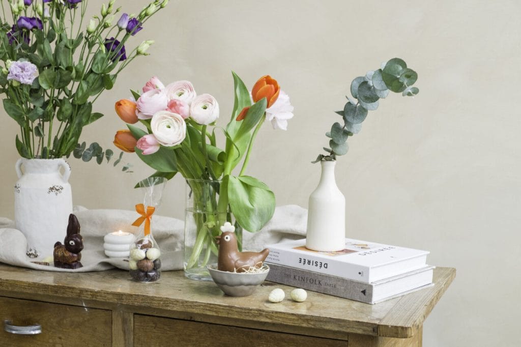 decorare il tavolo di pasqua con un bouquet di fiori in vasi trasparenti e bianchi