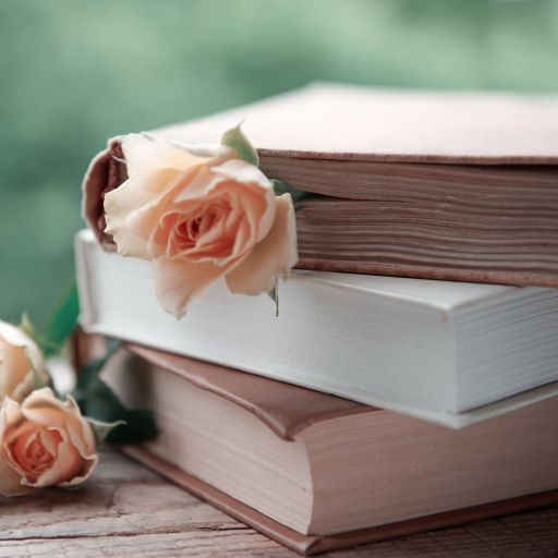 Libri impilati con un fiore tra le pagine